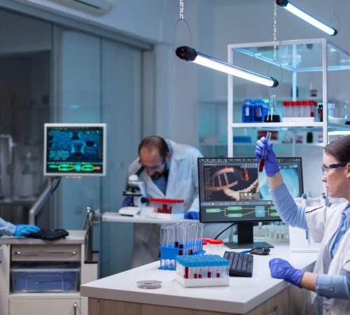 Team of scientific researchers working with professional modern equipment in laboratory. Chemists in pharmaceutical lab examining sample for medical experiment with technology for medicine industry.